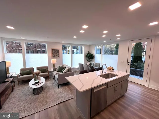 a living room with furniture wooden floor and a large window