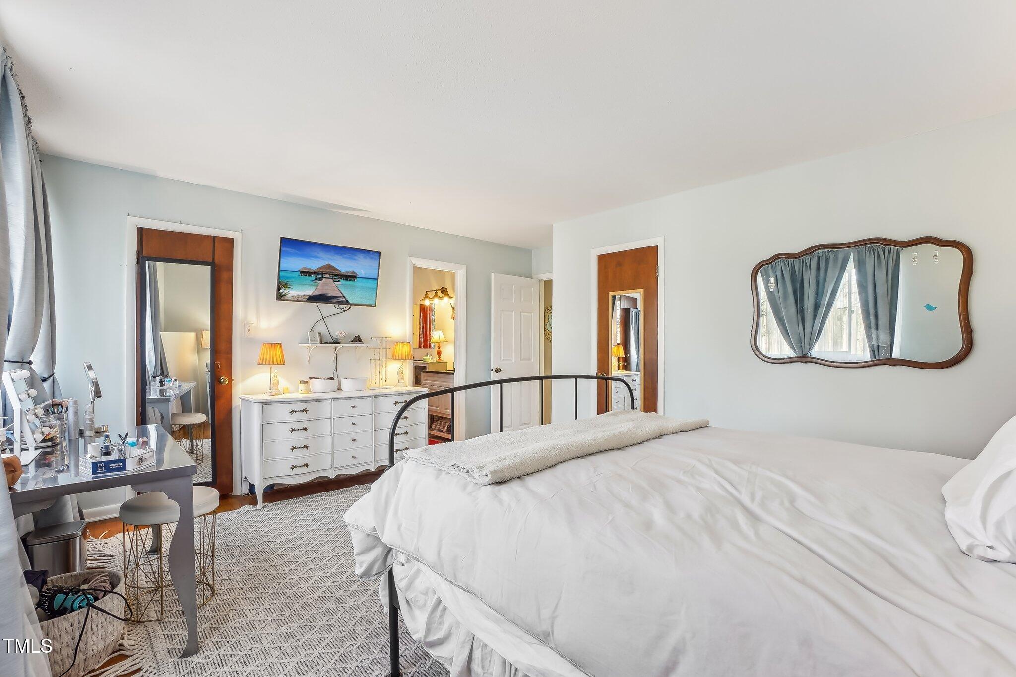 5410 Thayer Drive Raleigh, NC 27612 - Photo 16 of 36 a bedroom with a bed and dresser with mirror