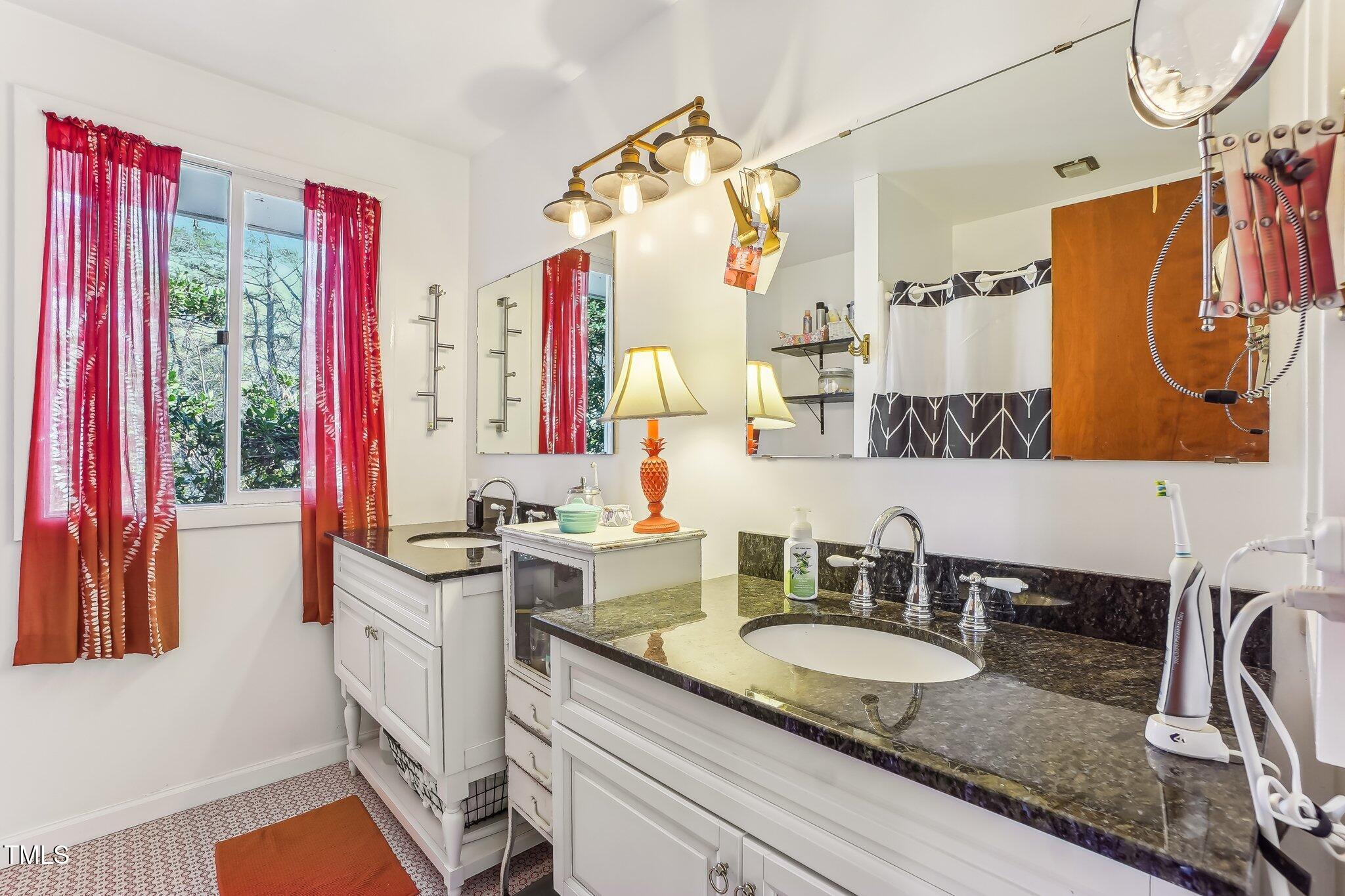 5410 Thayer Drive Raleigh, NC 27612 - Photo 17 of 36 a bathroom with a granite countertop sink a vanity and a mirror