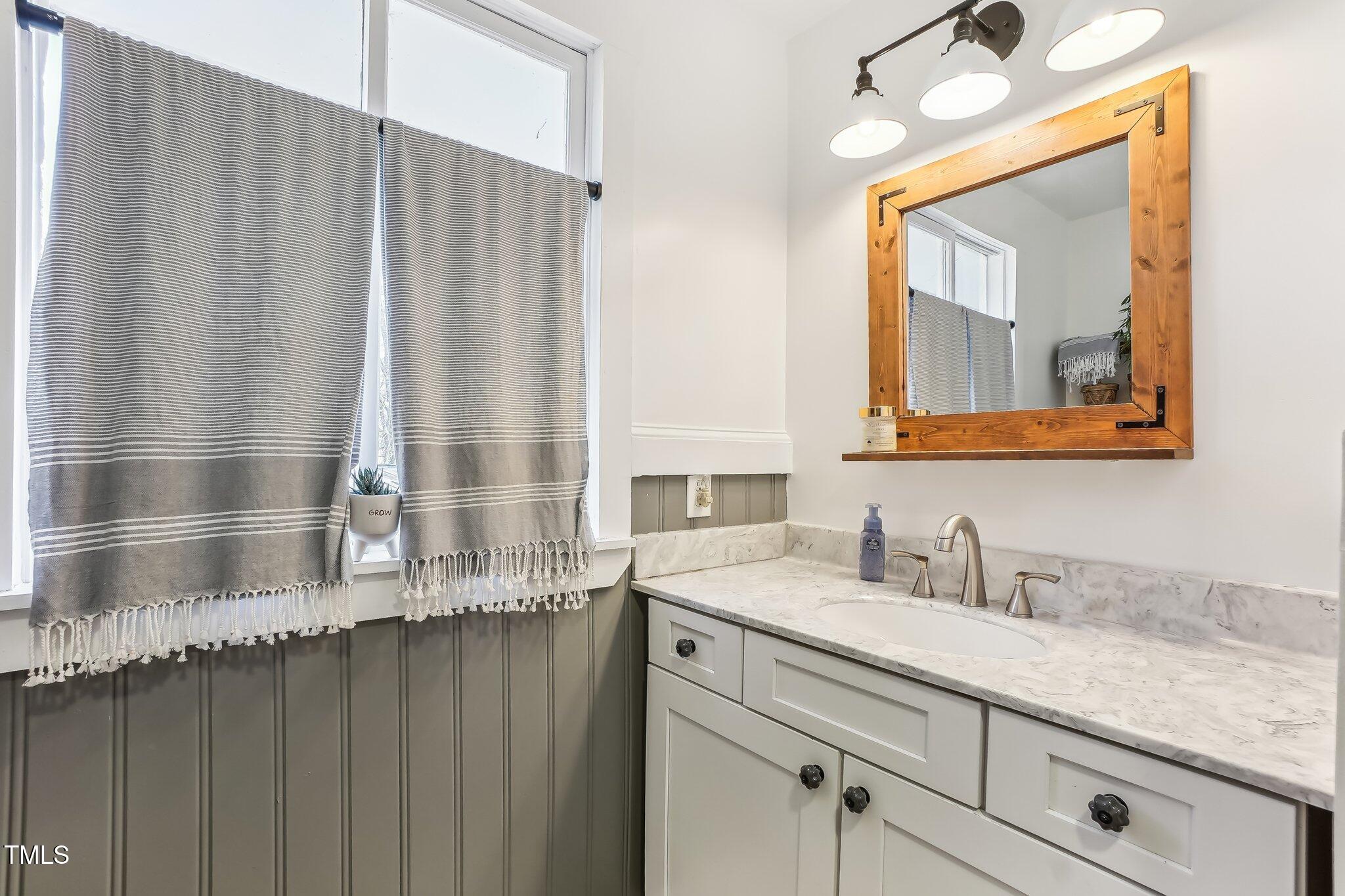 5410 Thayer Drive Raleigh, NC 27612 - Photo 24 of 36 a bathroom with a sink and a mirror