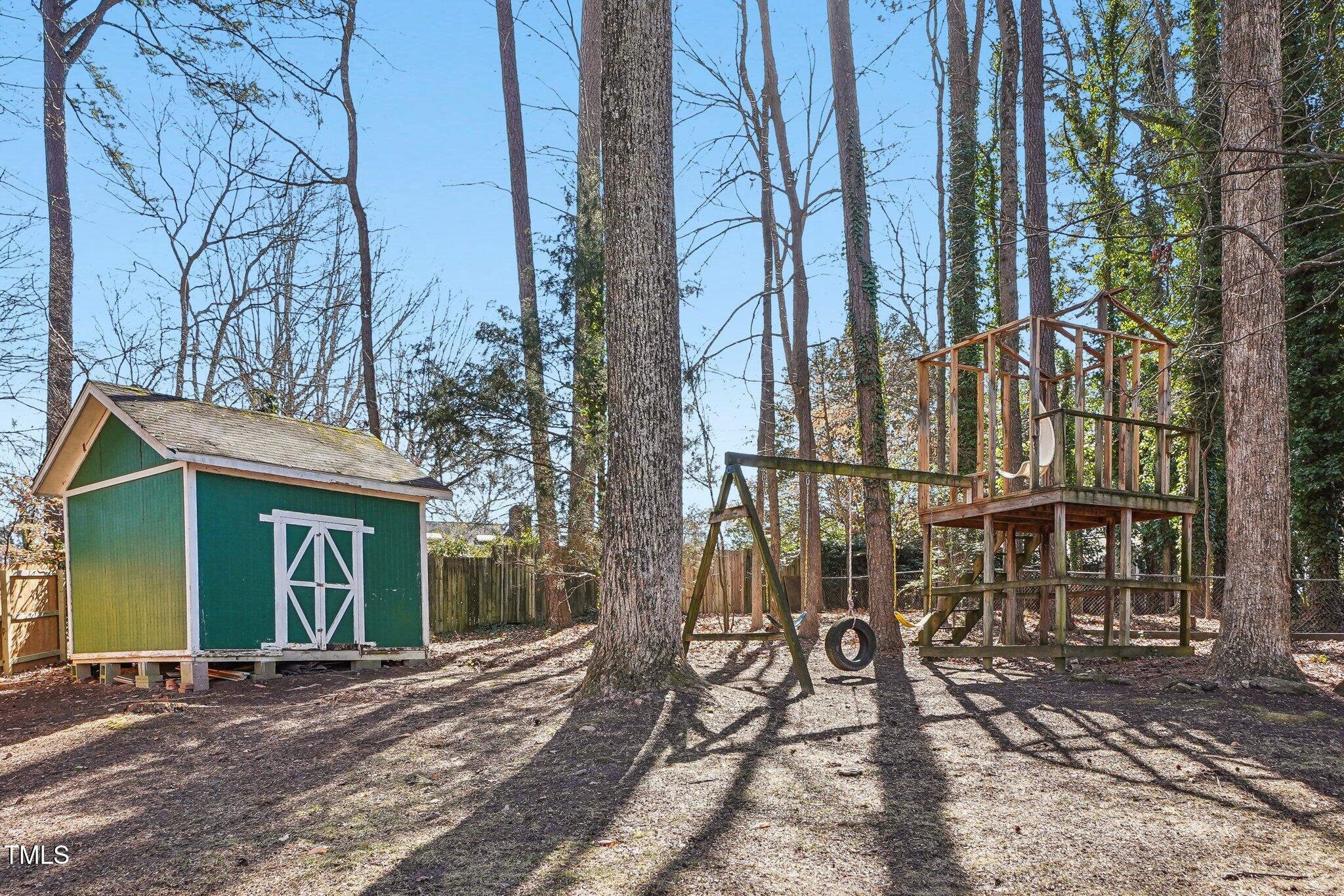 5410 Thayer Drive Raleigh, NC 27612 - Photo 34 of 36 a view of a brick house with large windows and a tree