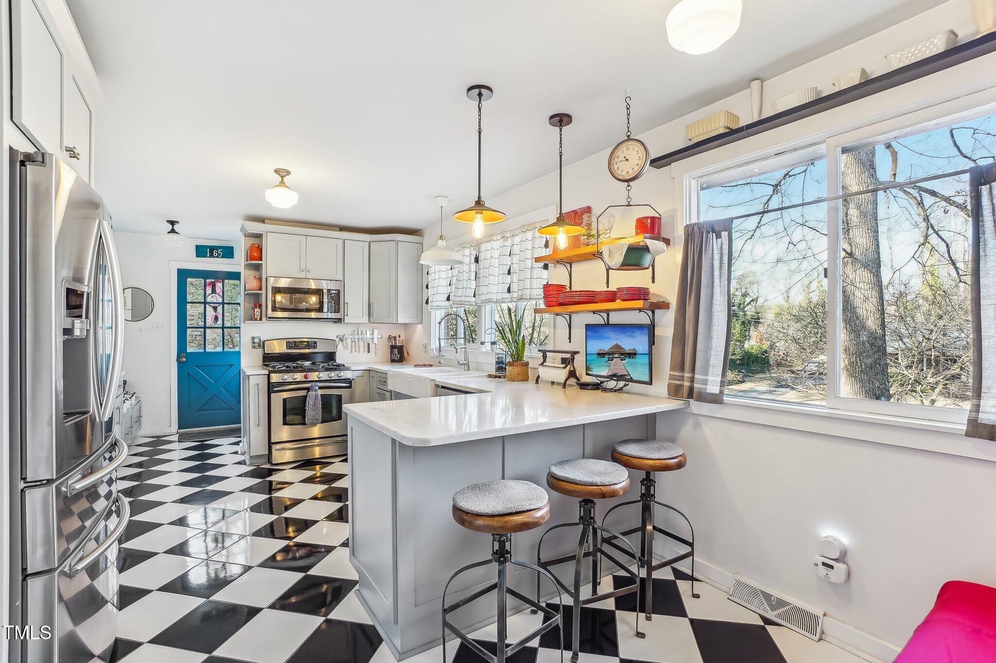 5410 Thayer Drive Raleigh, NC 27612 - Photo 5 of 36 a kitchen with stainless steel appliances a stove a sink and a refrigerator