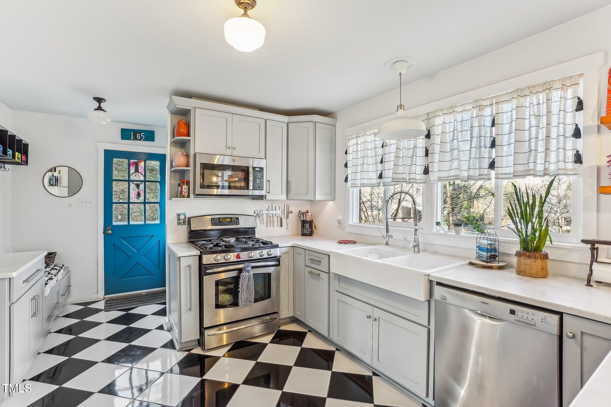 5410 Thayer Drive Raleigh, NC 27612 - Photo 6 of 36 a kitchen with stainless steel appliances a stove a sink and a refrigerator