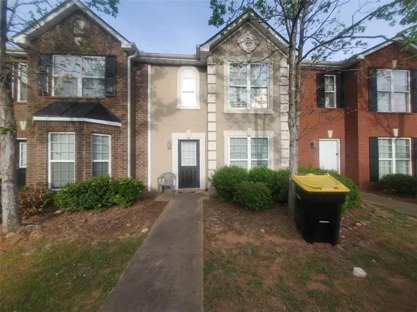 front view of a brick house with a yard