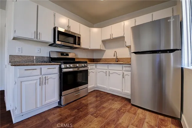 a kitchen with white cabinets and stainless steel appliances