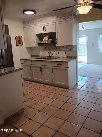 a view of a refrigerator in kitchen and an empty room