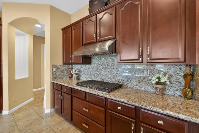 a kitchen with stainless steel appliances granite countertop a sink a stove a refrigerator and a center island