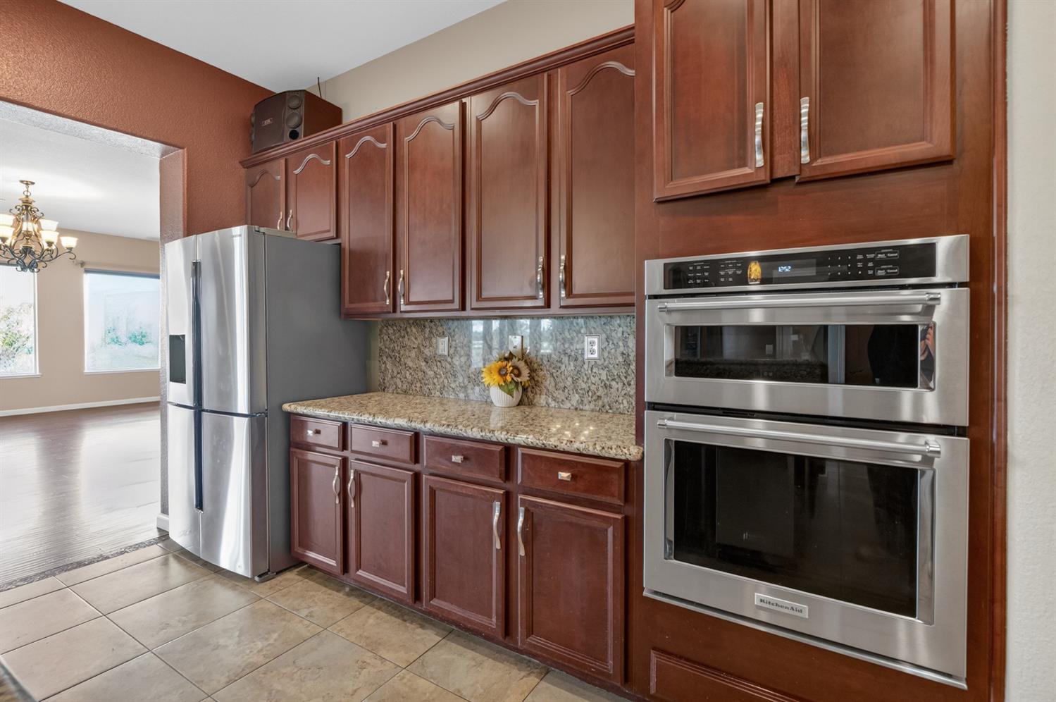 9601 Stablegate Road Wilton, CA 95693 - Photo 20 of 92 a kitchen with granite countertop wooden cabinets and stainless steel appliances