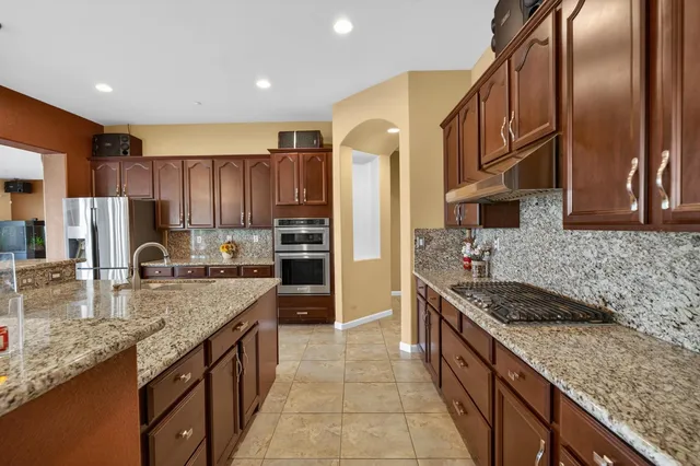 a bathroom with a granite countertop sink a large mirror and a window