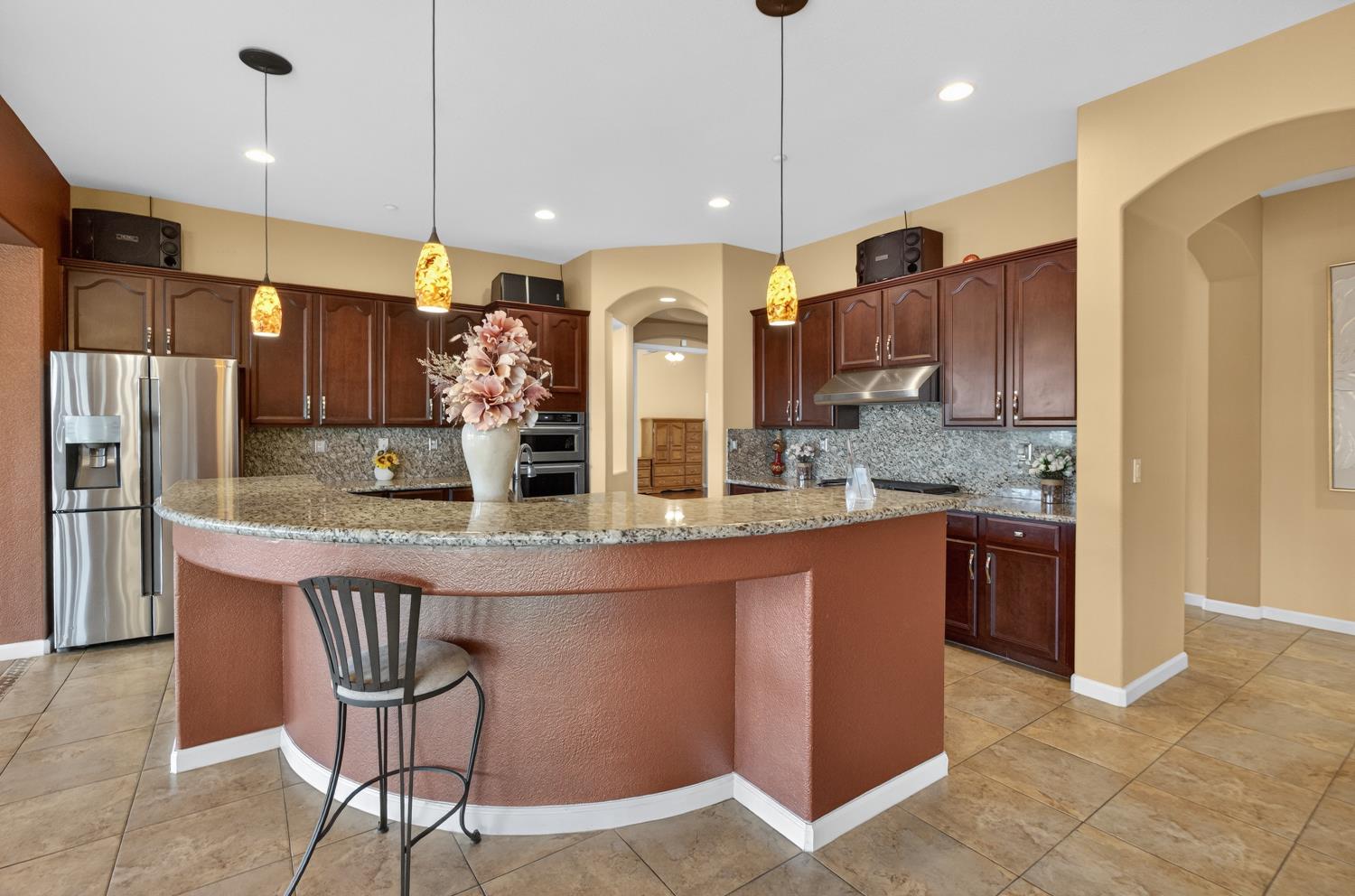 9601 Stablegate Road Wilton, CA 95693 - Photo 23 of 92 a kitchen with stainless steel appliances granite countertop a sink a stove a refrigerator and a center island
