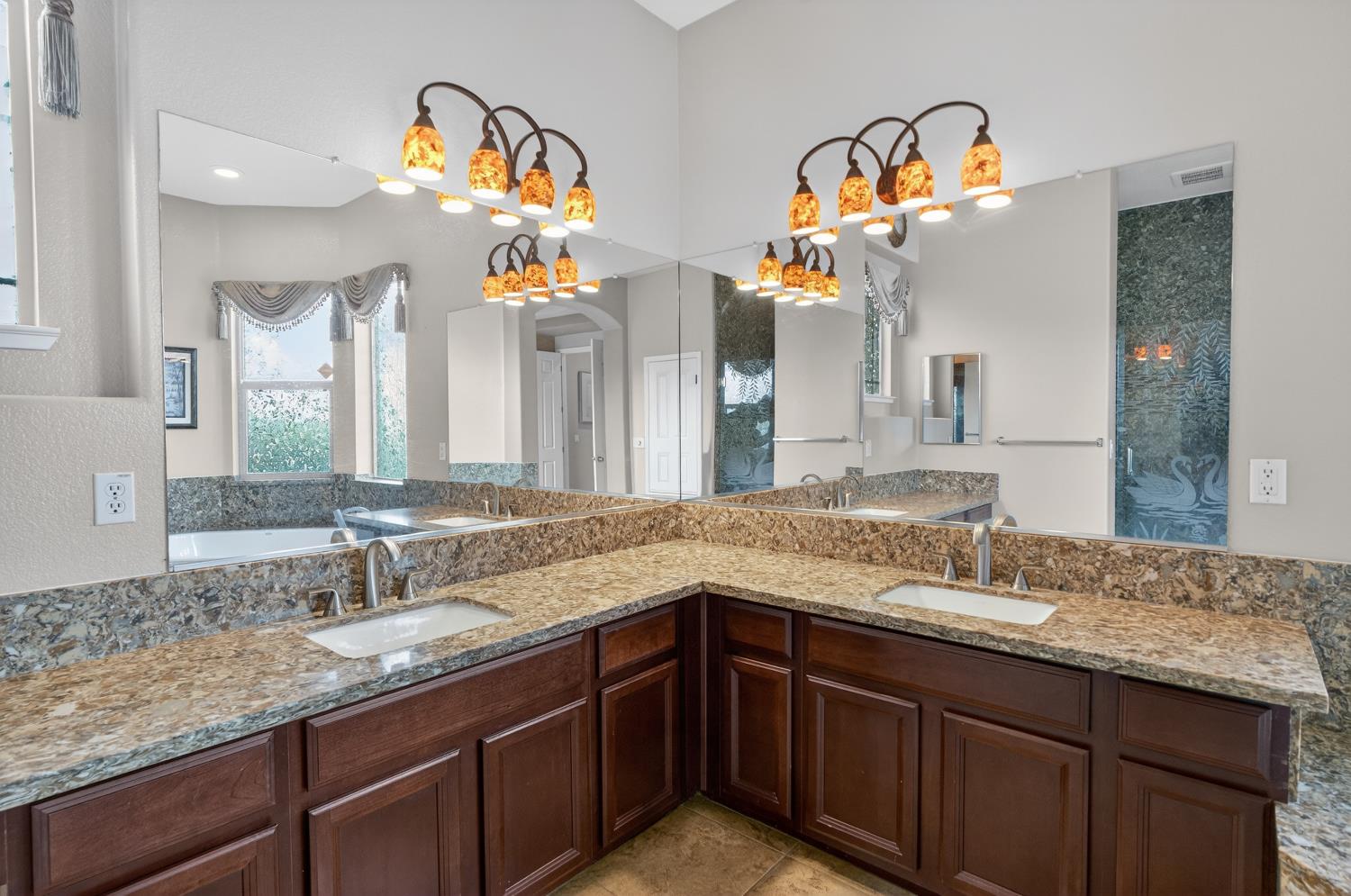 9601 Stablegate Road Wilton, CA 95693 - Photo 38 of 92 a bathroom with a granite countertop sink a large mirror and a window