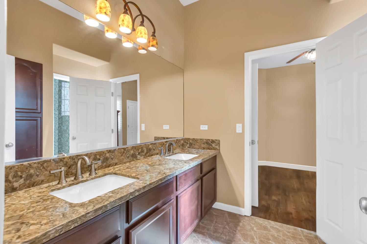 9601 Stablegate Road Wilton, CA 95693 - Photo 43 of 92 a bathroom with a granite countertop double vanity sink and a mirror