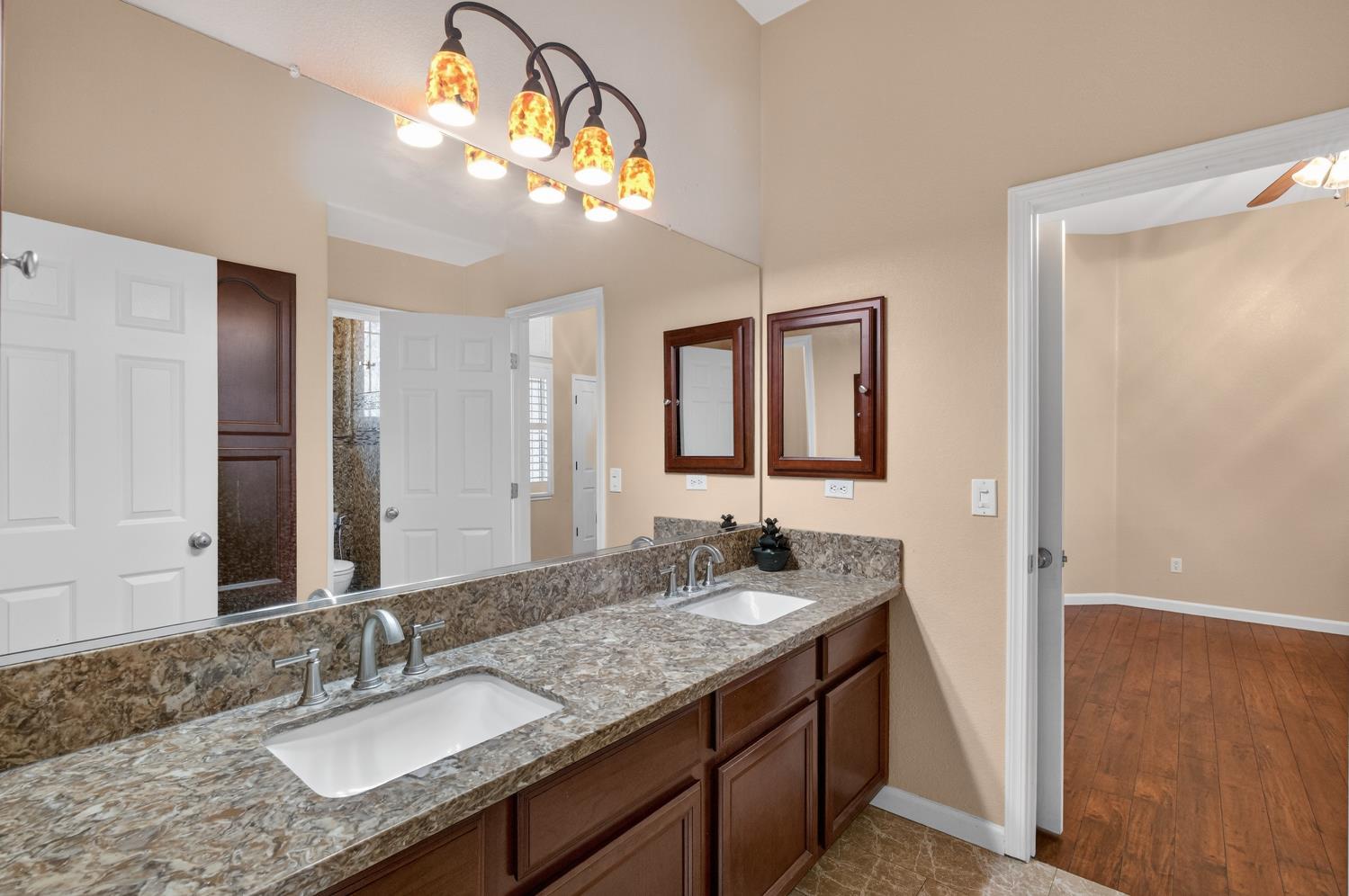 9601 Stablegate Road Wilton, CA 95693 - Photo 53 of 92 a bathroom with a granite countertop sink double vanity and a mirror