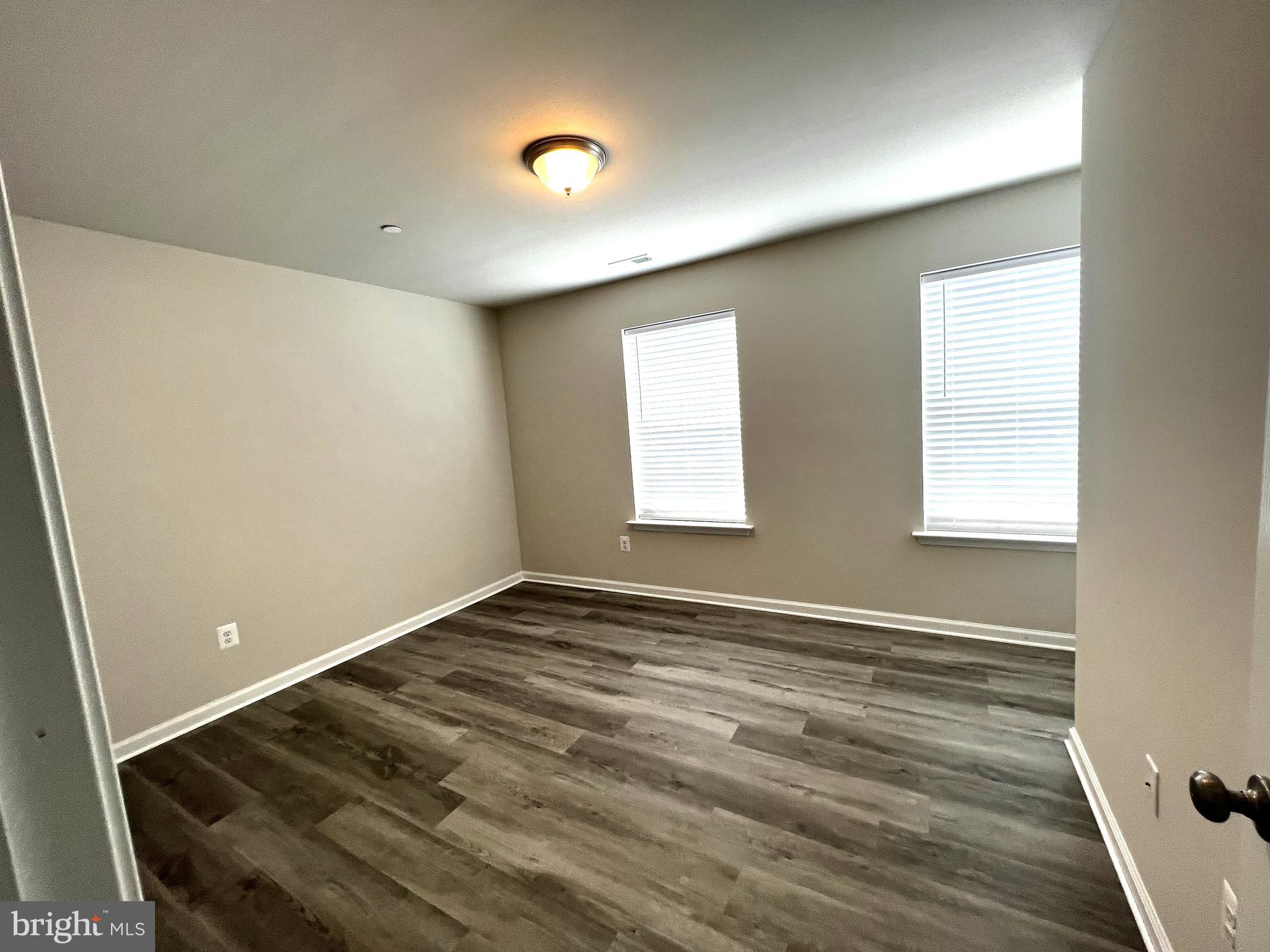 100 North 6th Street, Unit 100 Denton, MD 21629 - Photo 5 of 10 an empty room with wooden floor and windows