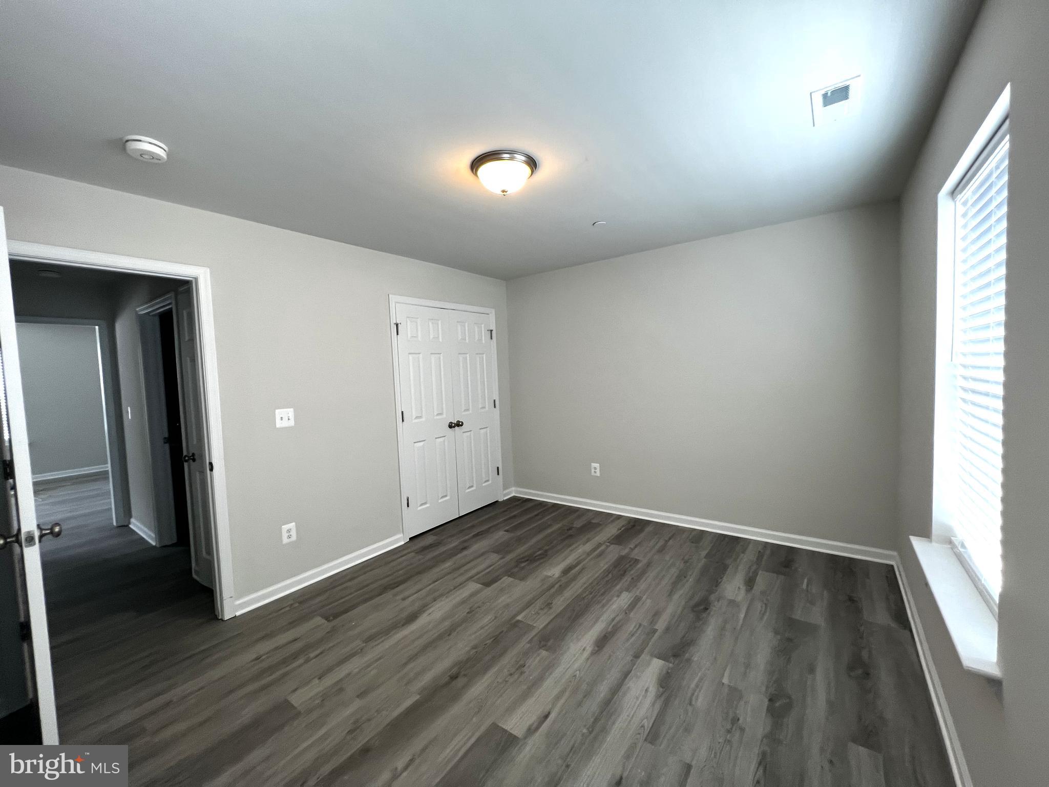 100 North 6th Street, Unit 100 Denton, MD 21629 - Photo 6 of 10 an empty room with wooden floor and windows