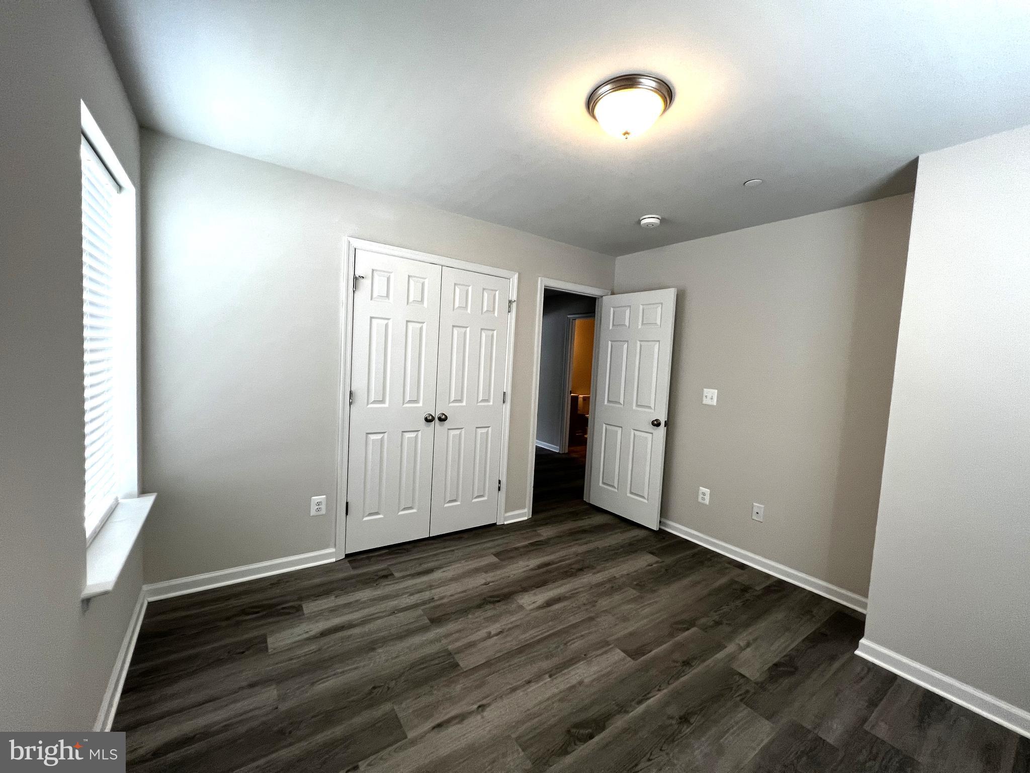 100 North 6th Street, Unit 100 Denton, MD 21629 - Photo 8 of 10 an empty room with wooden floor and windows