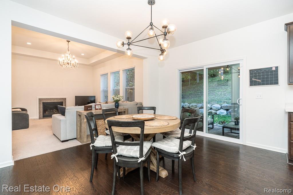 201 Beechview Drive Rochester, MI 48306 - Photo 15 of 49 Recessed lighting, a gas fireplace with stone surround, wood-finish flooring, and a sliding glass door providing outdoor access