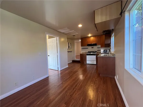 a view of kitchen with microwave stove refrigerator and wooden floor