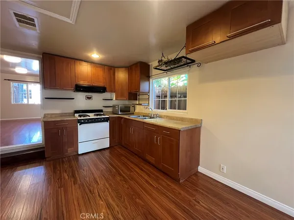 a kitchen with stainless steel appliances kitchen island granite countertop a stove a sink and a refrigerator