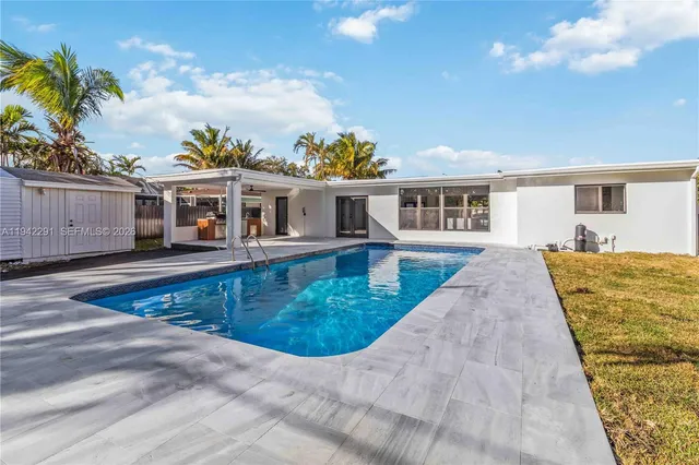 swimming pool view with a seating space and a garden view
