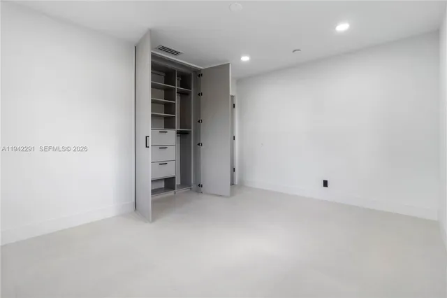 an empty room with a closet and cabinet