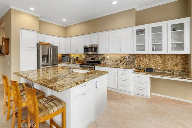 a kitchen with granite countertop a sink stove and cabinets