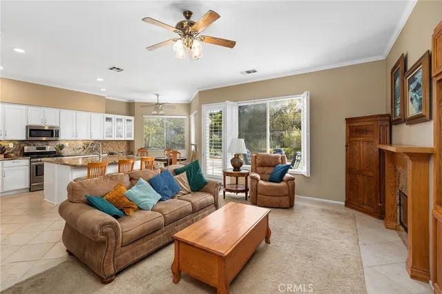 a living room with furniture kitchen view and a window
