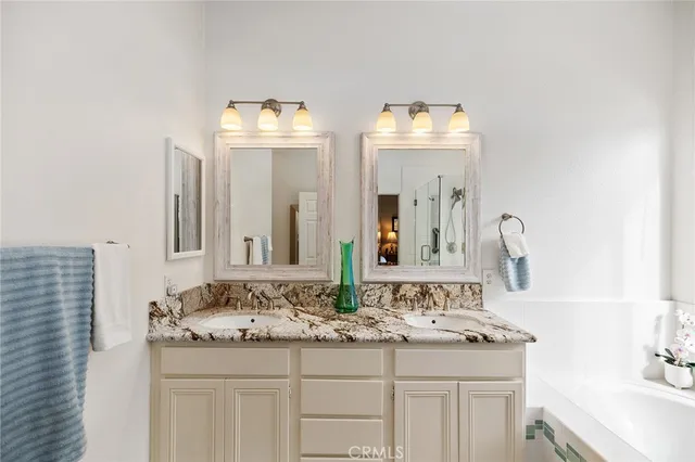 a bathroom with double sink and a mirror
