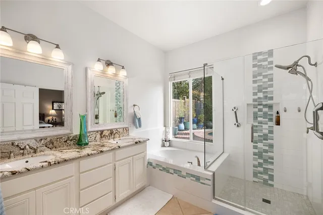 a bathroom with a granite countertop sink mirror and a shower
