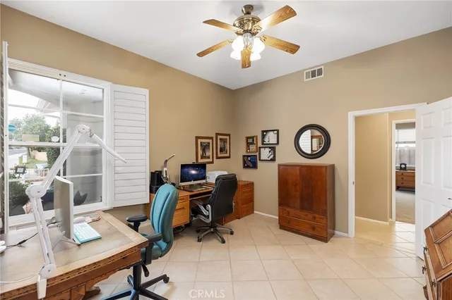 a view of a workspace with furniture and a window