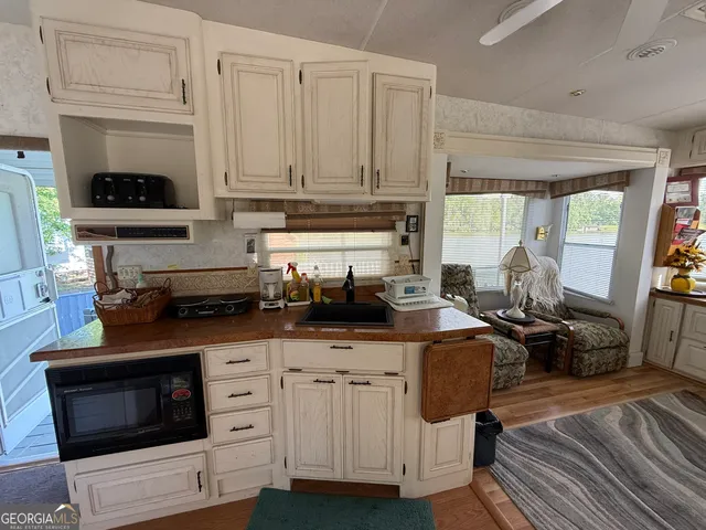 a kitchen with stainless steel appliances a stove a sink a stove and white cabinets