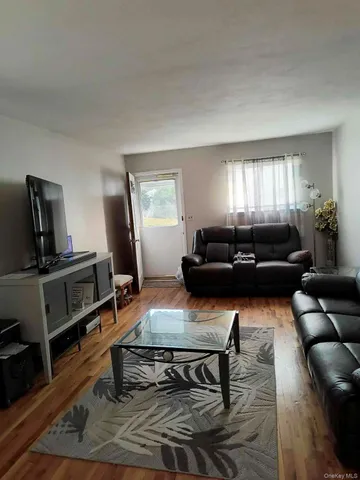 a living room with furniture a window and a flat screen tv