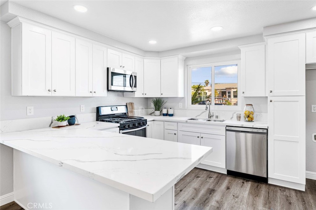 445 Via Val Verde Montebello, CA 90640 - Photo 13 of 51 a kitchen with stainless steel appliances white cabinets a sink a stove a refrigerator and white cabinets