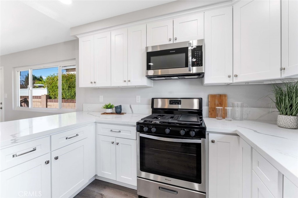 445 Via Val Verde Montebello, CA 90640 - Photo 16 of 51 a kitchen with white cabinets and black appliances