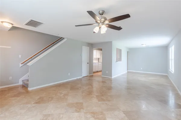 a view of an empty room with a chandelier fan
