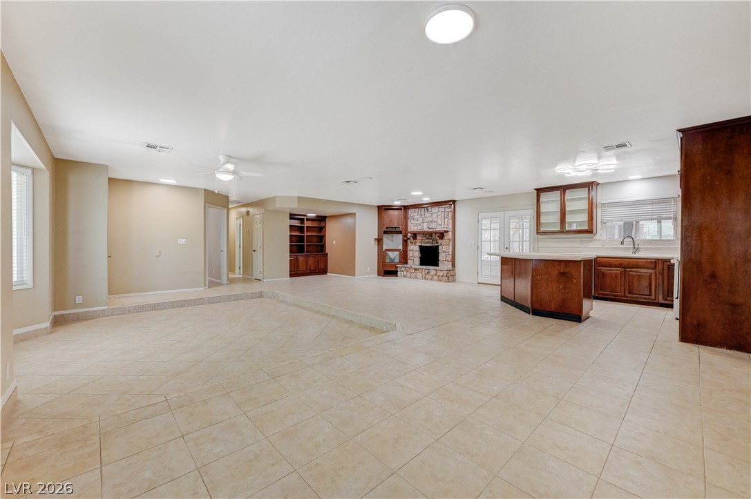 7631 Bermuda Road Las Vegas, NV 89123 - Photo 15 of 64 A spacious, open-concept living area with a cozy stone fireplace and integrated kitchen space.