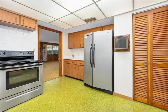 a kitchen with stainless steel appliances a refrigerator a stove and white cabinets