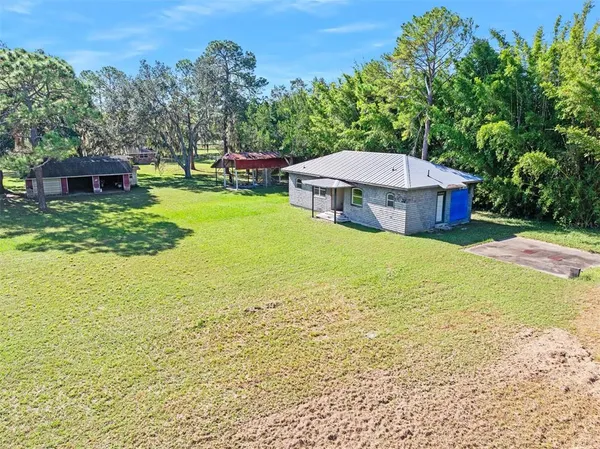 a view of a house with a yard and a large tree