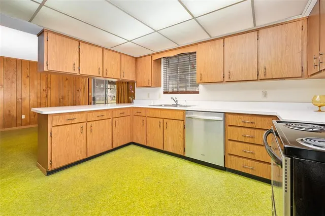 a kitchen with stainless steel appliances granite countertop a sink a stove cabinets and wooden floor