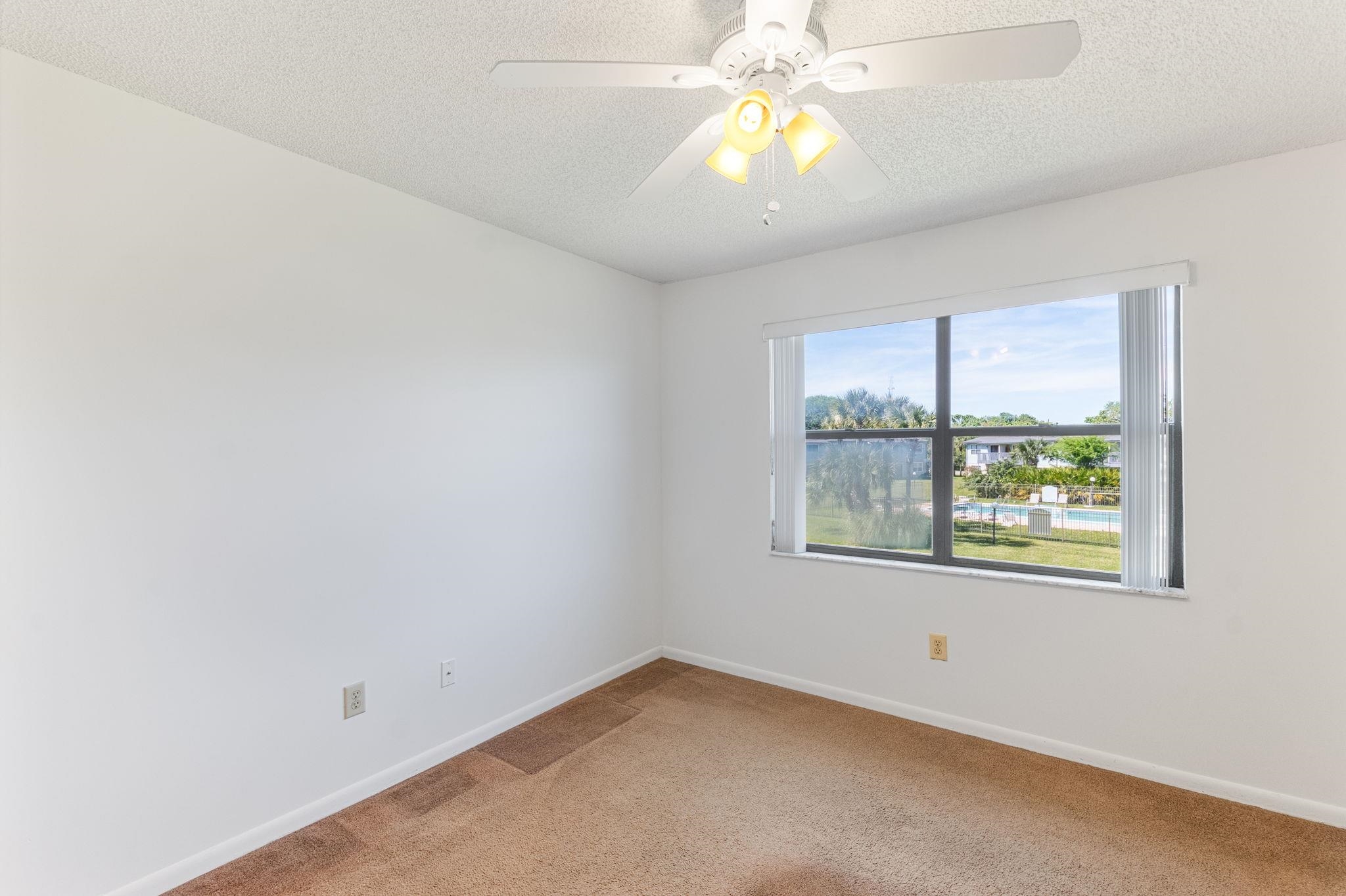 700 West Pope Road, Unit D28 St. Augustine, FL 32080 - Photo 15 of 32 Carpeted spare room featuring ceiling fan and a textured ceiling
