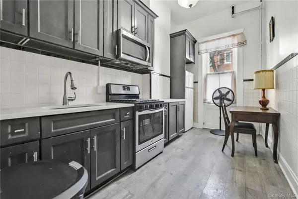 a kitchen with stainless steel appliances granite countertop a refrigerator a stove and a sink