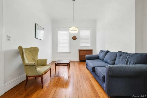 a living room with couches a dining table and chairs with wooden floor