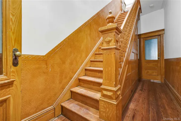 a view of a hallway with wooden floor and staircase