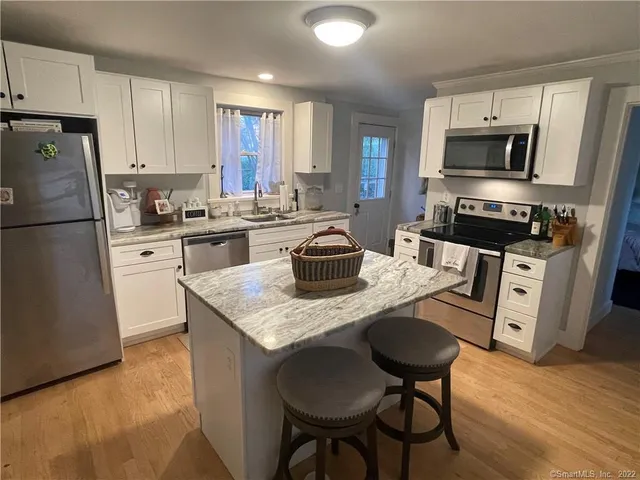 a kitchen with granite countertop a sink stove and refrigerator