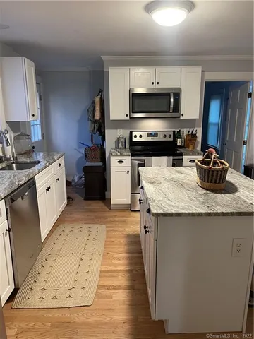 a kitchen with sink a microwave and cabinets