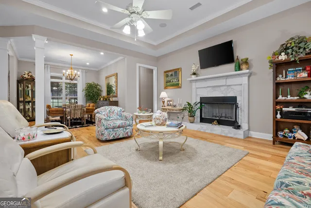 a kitchen with stainless steel appliances kitchen island granite countertop a refrigerator a stove a sink and a dining table with wooden floor