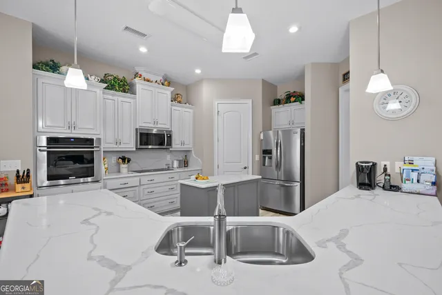 a bedroom with a large bed and a flat tv screen on dresser