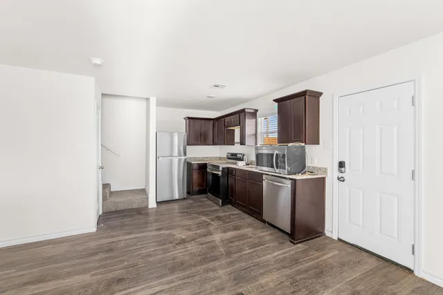 a kitchen with stainless steel appliances granite countertop a refrigerator and a sink