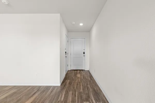 a view of a room with wooden floor and white walls