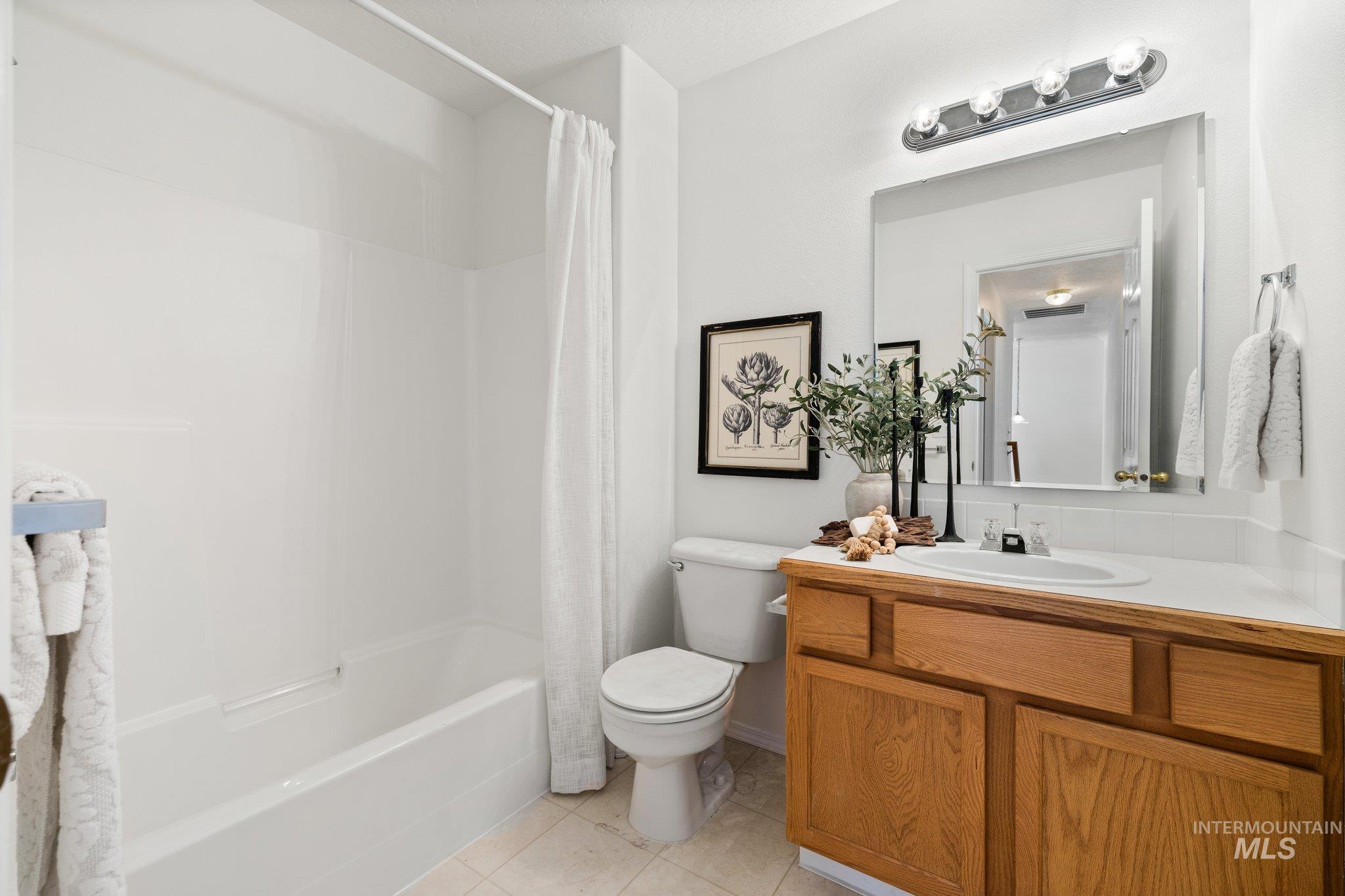 2900 South Ladera Place Boise, ID 83705 - Photo 26 of 31 Full bath featuring vanity, shower / bathtub combination with curtain, and light tile patterned floors